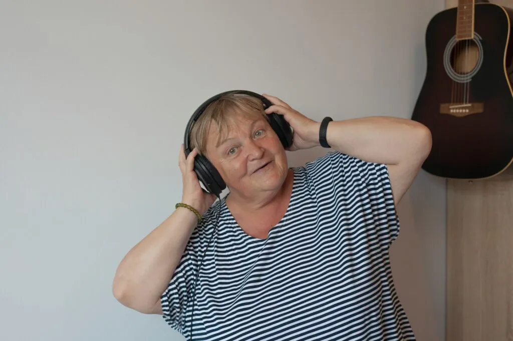 Happy older lady wearing headphones